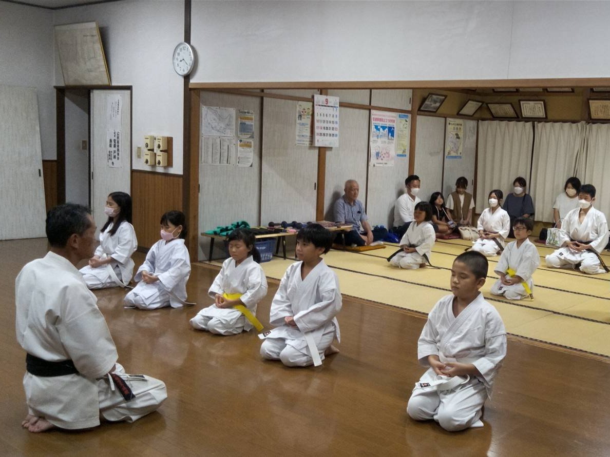 正座して並ぶ子どもたちと、向かい合う指導者